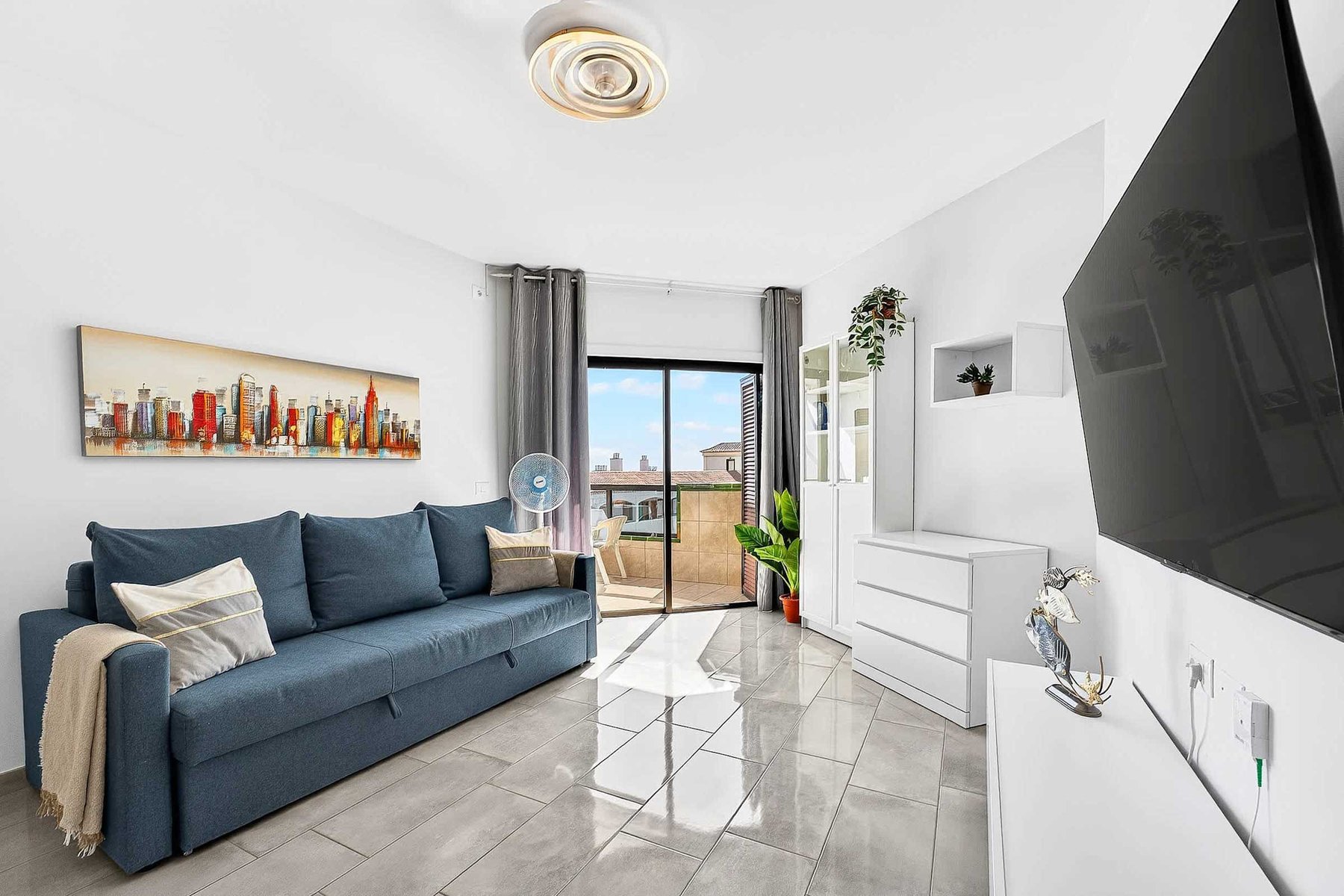 Livingroom with Dining Table, Sofa Bed, Flatscreen TV, and Balcony View