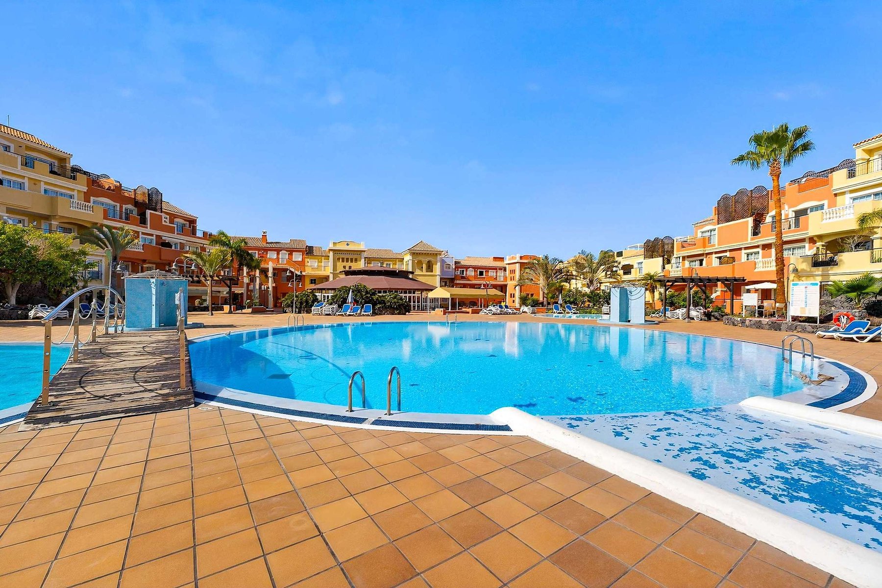 Heated Communal Swimming Pool Surrounded by Spacious Sunbathing Areas