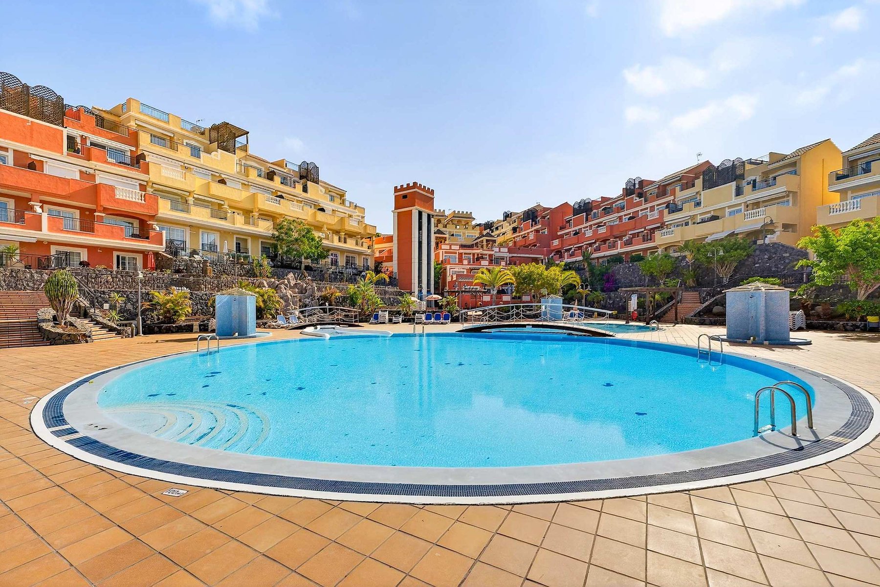 Heated Communal Swimming Pool Surrounded by Spacious Sunbathing Areas