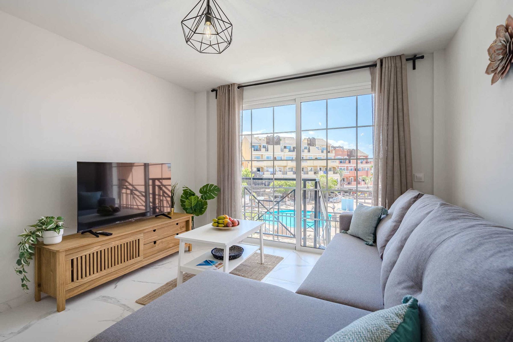 Living Room with TV, Sofa Bed, Dining Table, Coffee Table and Pool View