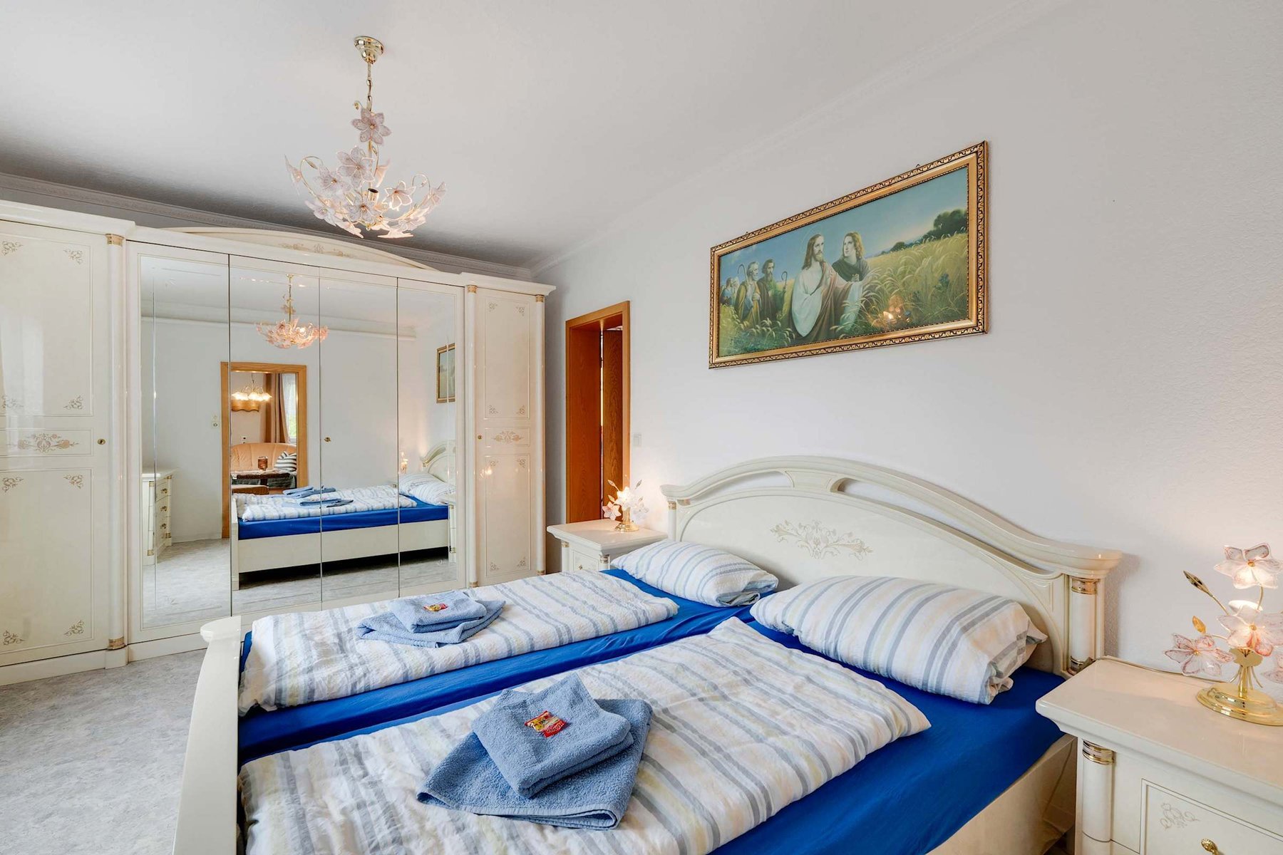Bright upper-floor Bedroom with Double Bed, Mirrored Wardrobes, and Elegant Lighting.