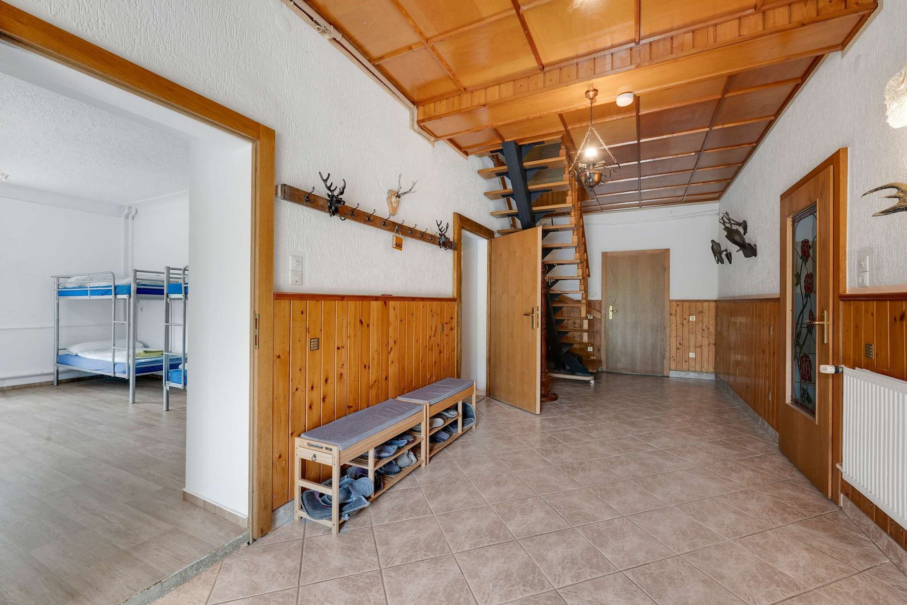 Welcoming Hallway with Coat Hooks and Rustic Wood Details.