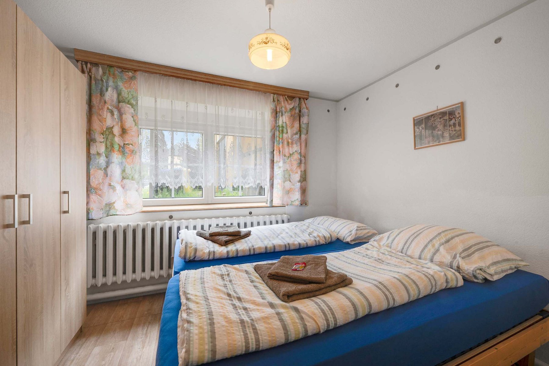 Cozy Twin Bedroom featuring, Soft Lighting, and a Large Wardrobe for storage.