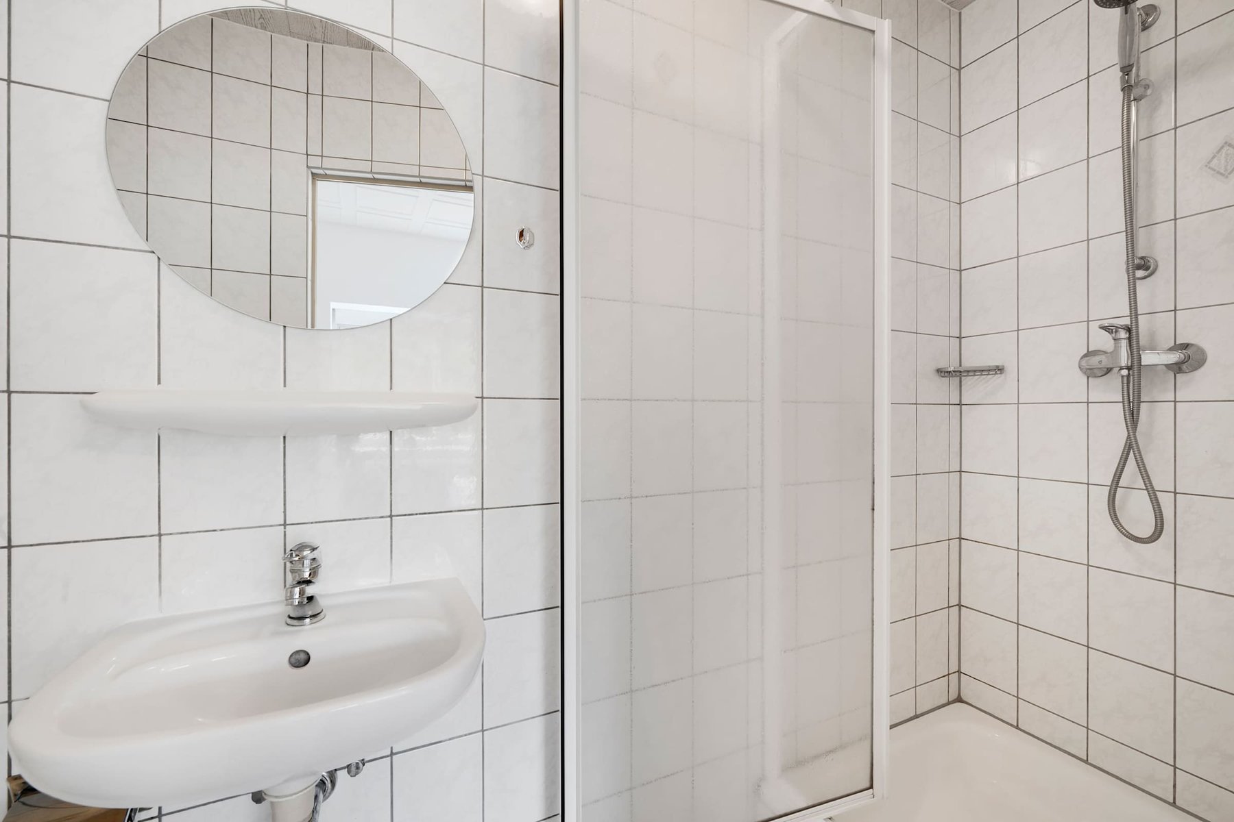 Bathroom with Walk-in Shower and Round Mirror.