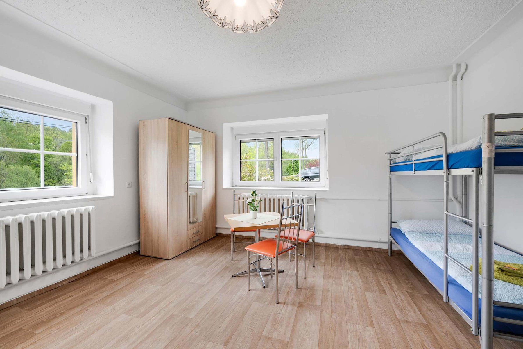 Bright, Airy Room with Bunk Bed, Wardrobe, and a small Table for writing, reading, or casual meals.