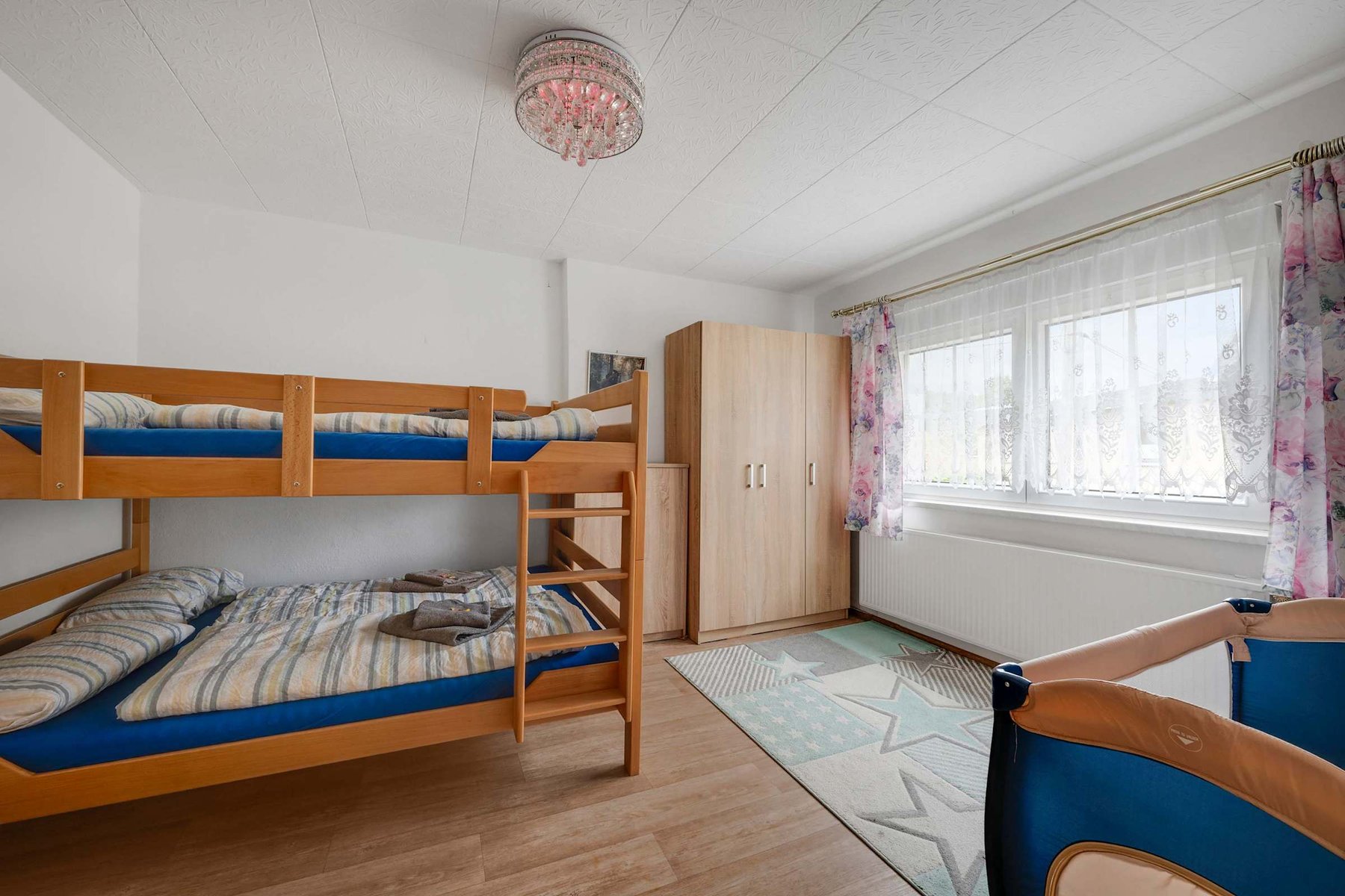 A Family-friendly Room with Bunk Bed, Wardrobe, Natural Light, and a Crib—perfect for guests with young children.