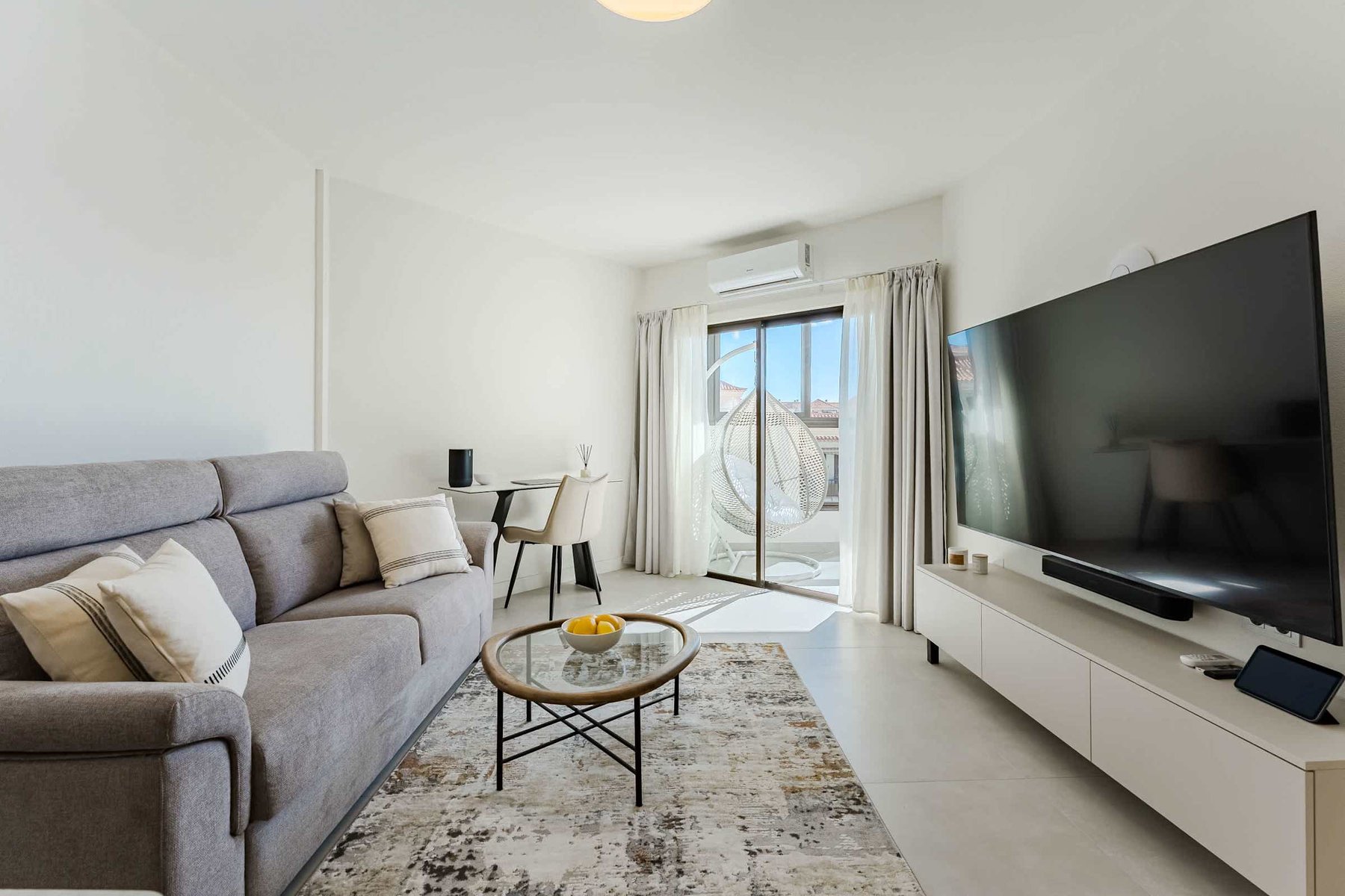 Bright Oceanfront Living Room with Designer Sofa, Oversized Flatscreen TV, Apple TV, Sonos Sound System & Elegant Workspace