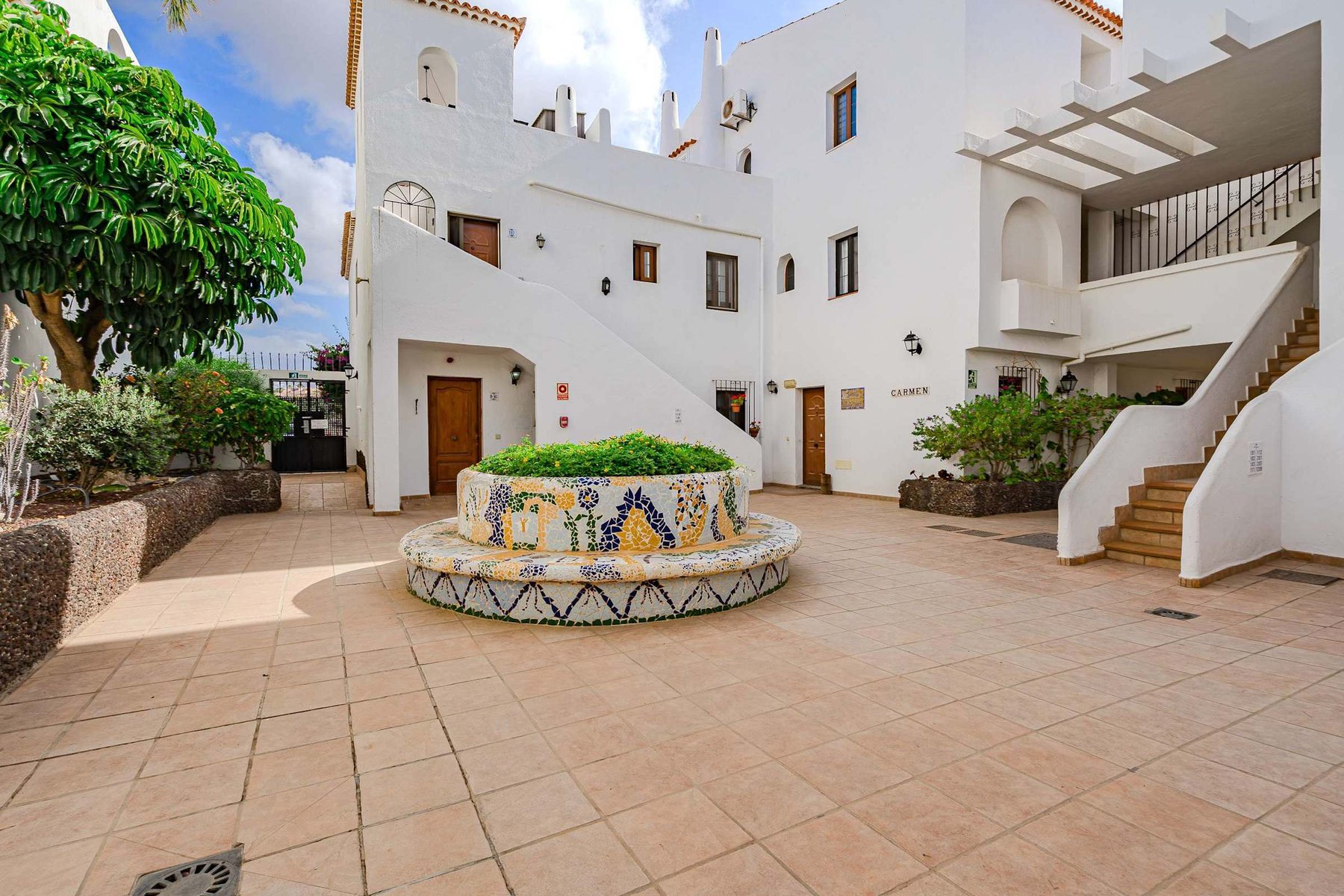 Traditional Courtyard with Mosaic — A Colorful Slice of Canary Island Charm Framed by Lush Greenery and Whitewashed Walls