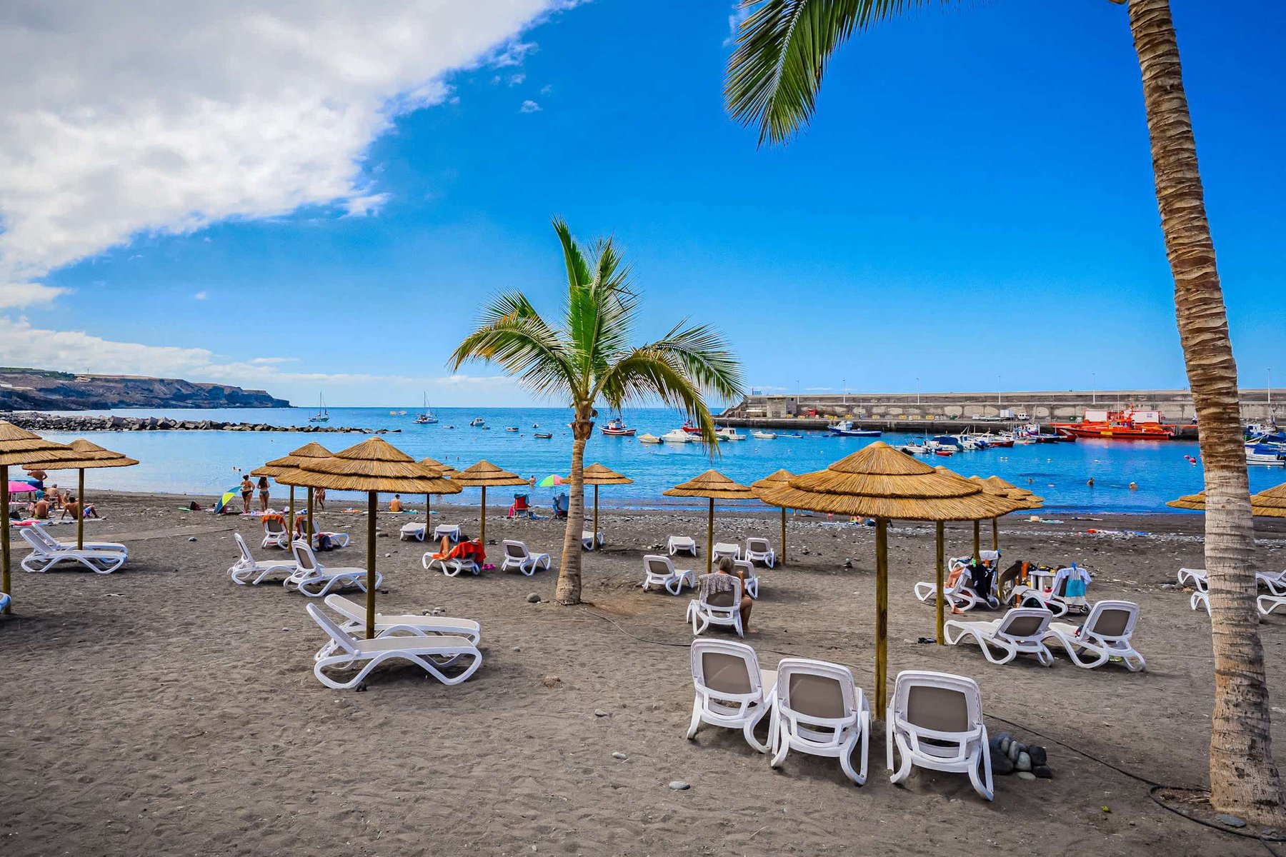 Sun-Drenched Shores – Relax Under Straw Parasols with Ocean Views
