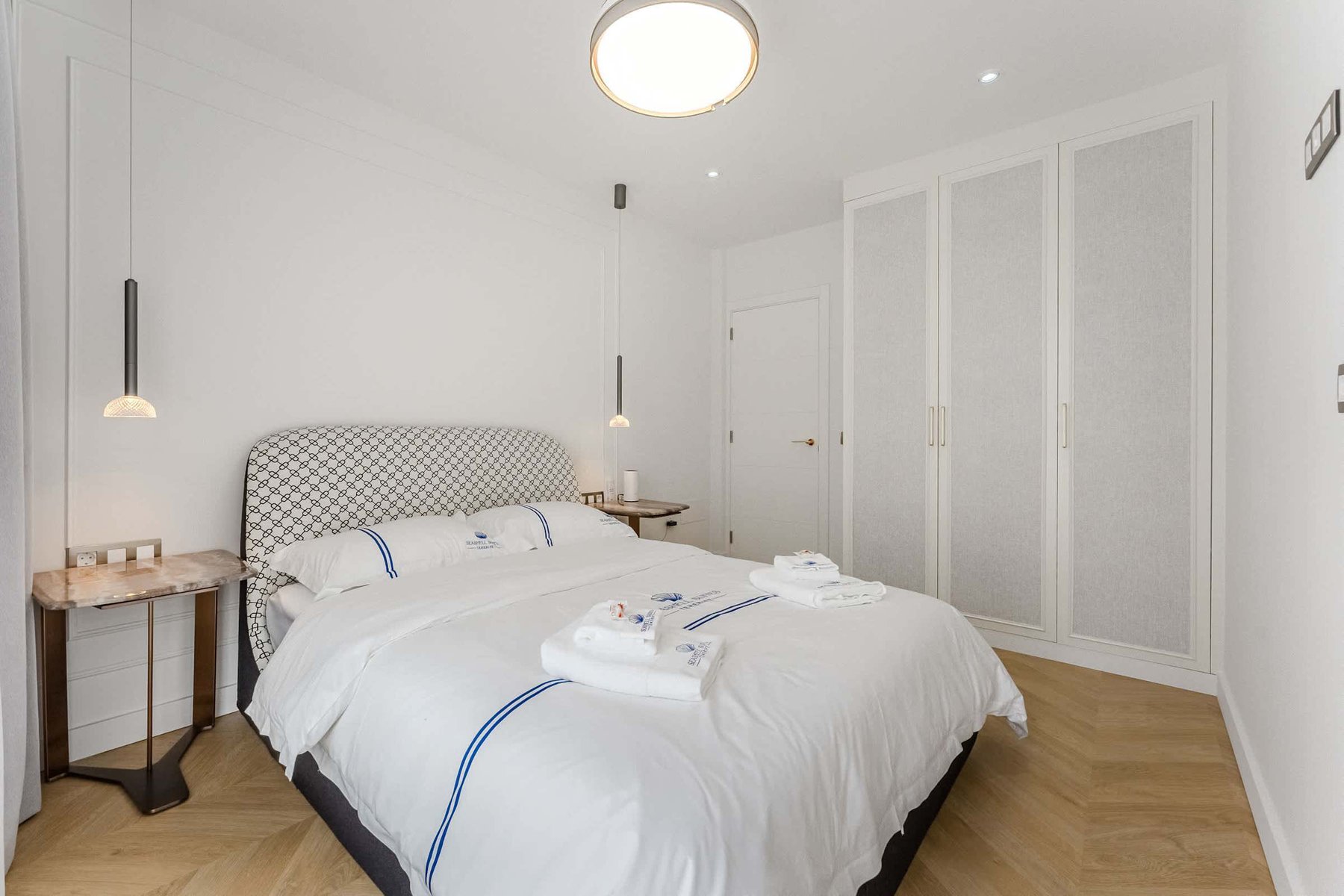 Refined Master Bedroom – Relax in a King-Size Bed Framed by Custom Lighting and Luxe Linens