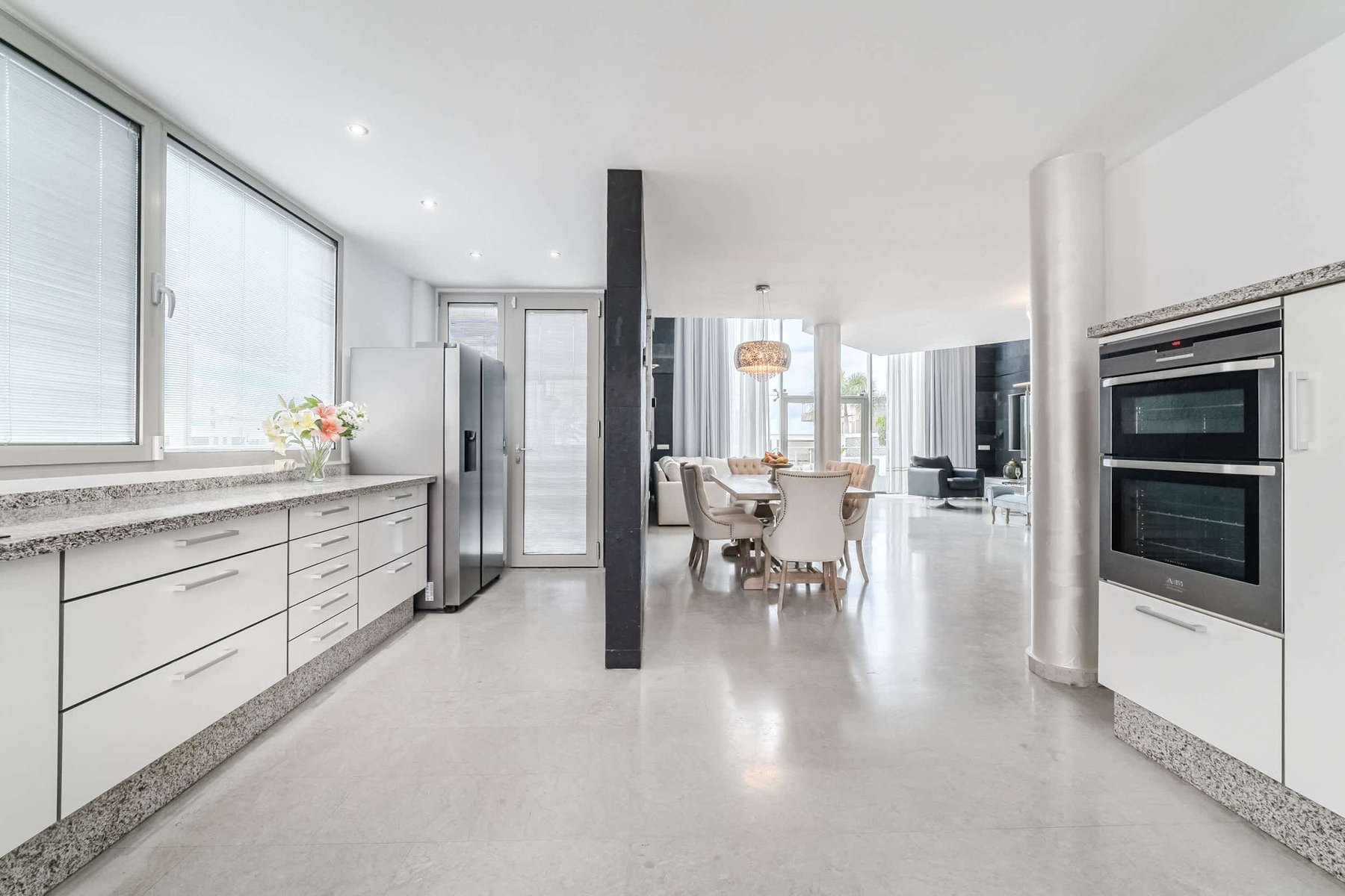 Open-Plan Kitchen and Dining - Elegant Granite Counters, Natural Light, and Spacious Layout for Gatherings