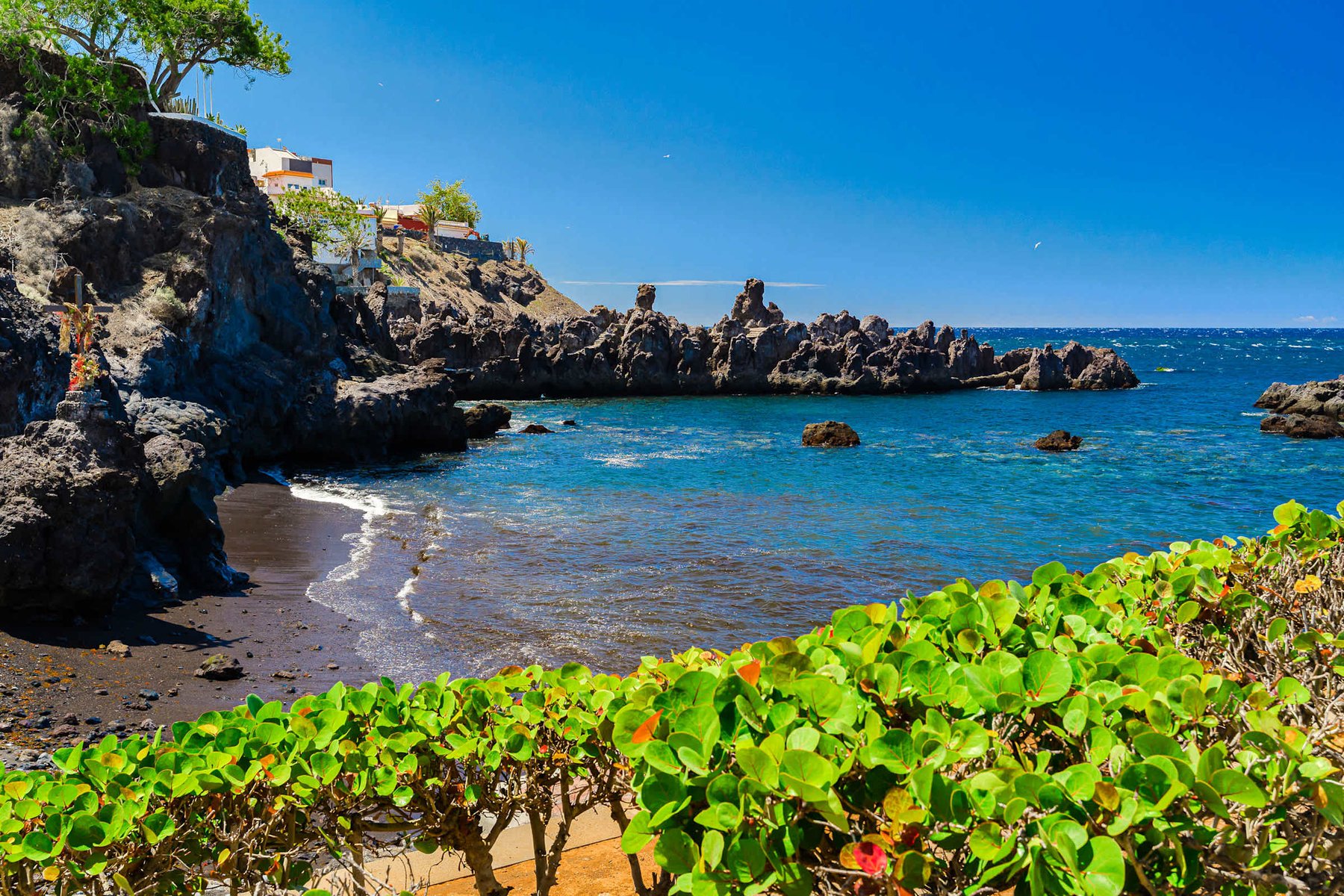 Cliffside Beach Cove - Black-Sand Beach framed by Volcanic Cliffs and Calm Blue Waters