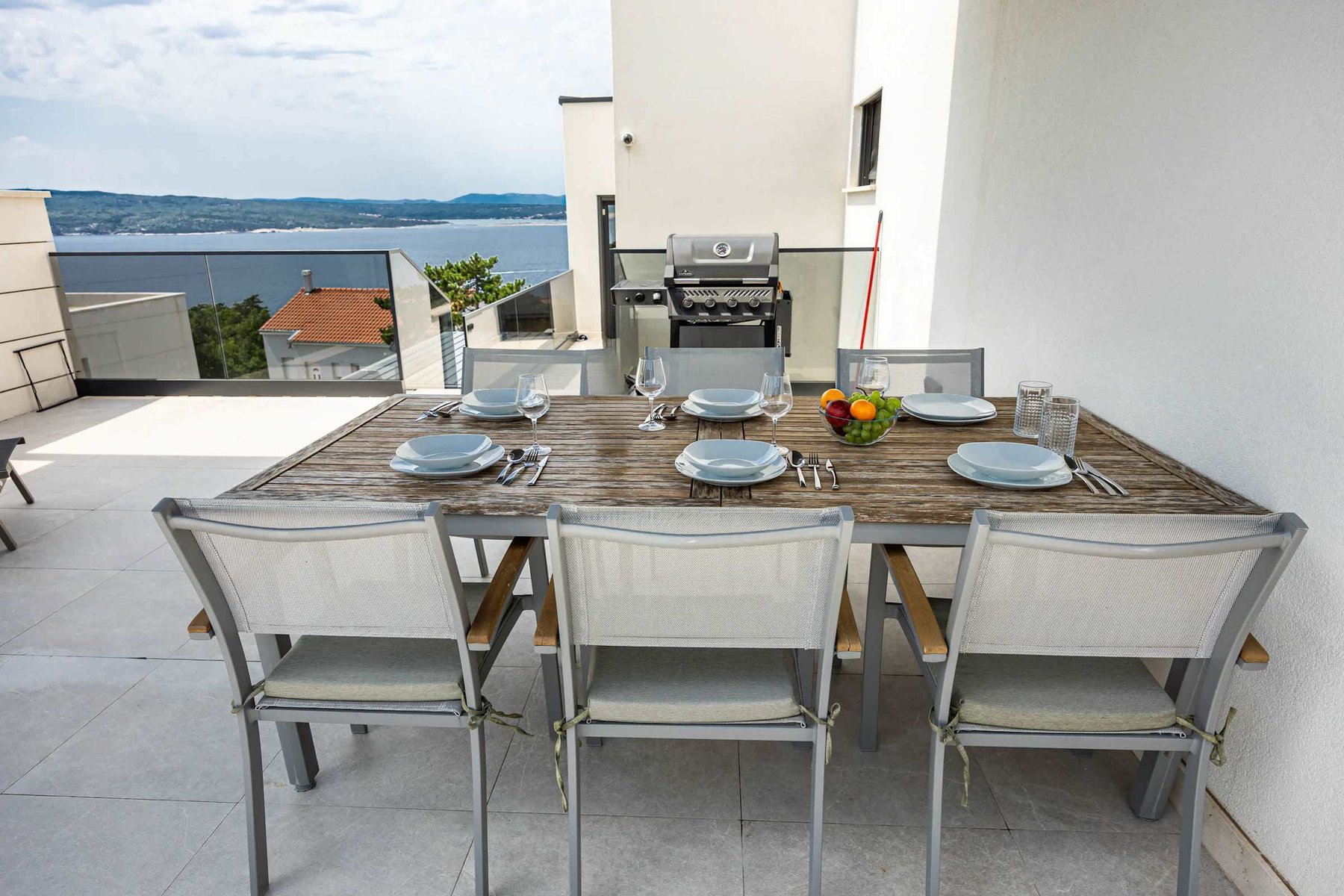 Outdoor dining table with gas BBQ and sea view