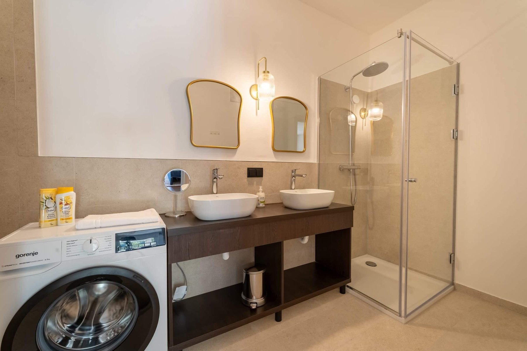 Bathroom with twin washbasins, walk-in shower and washing machine