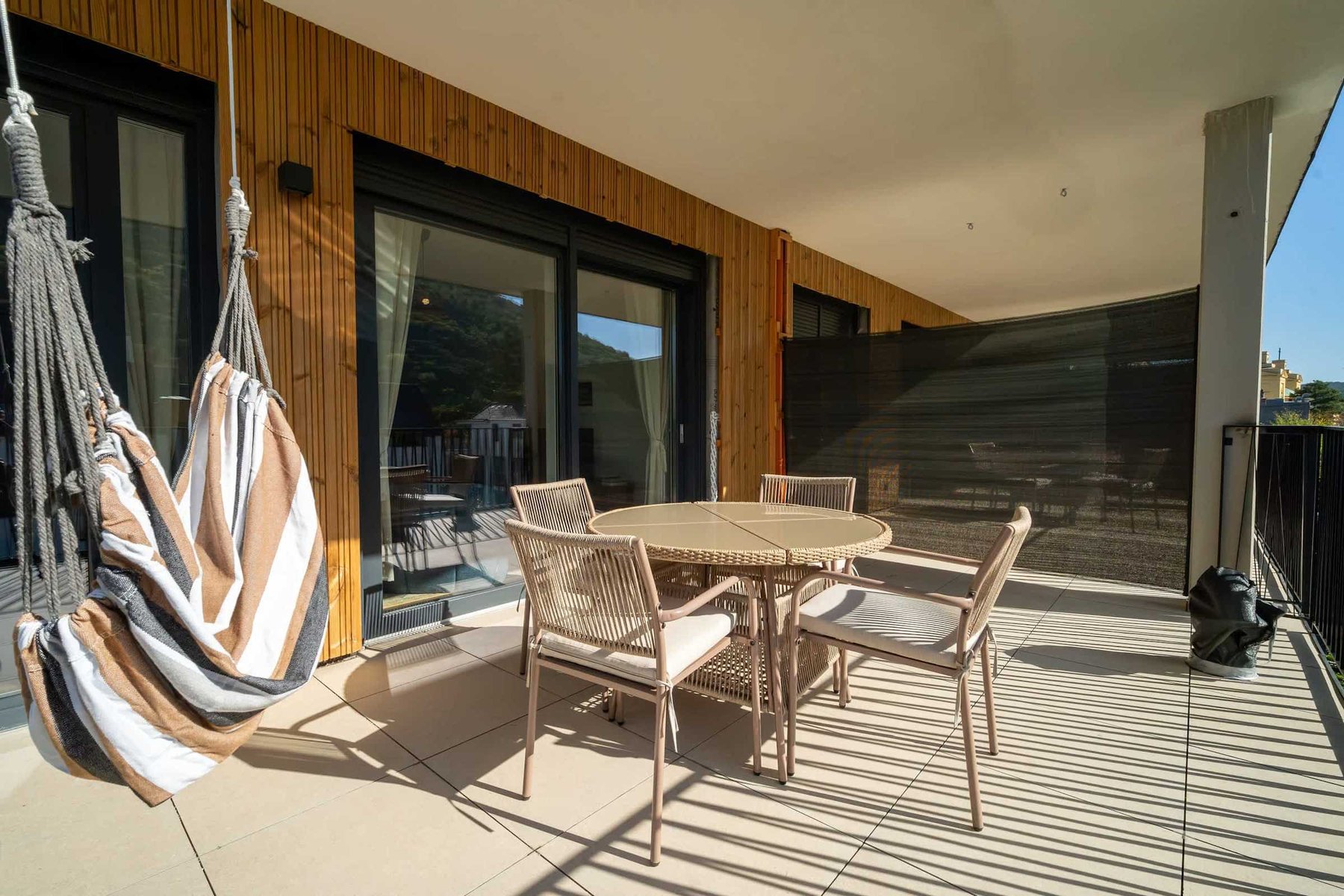 Balcony with hanging chairs and dining table
