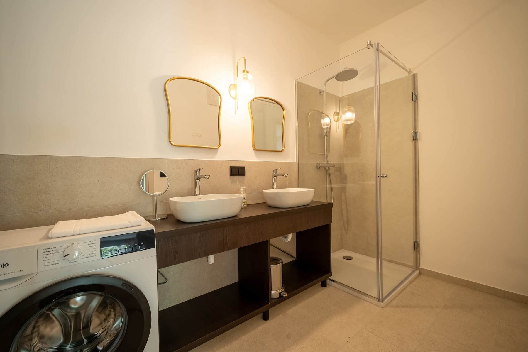 Bathroom with twin washbasins, walk-in shower and washing machine